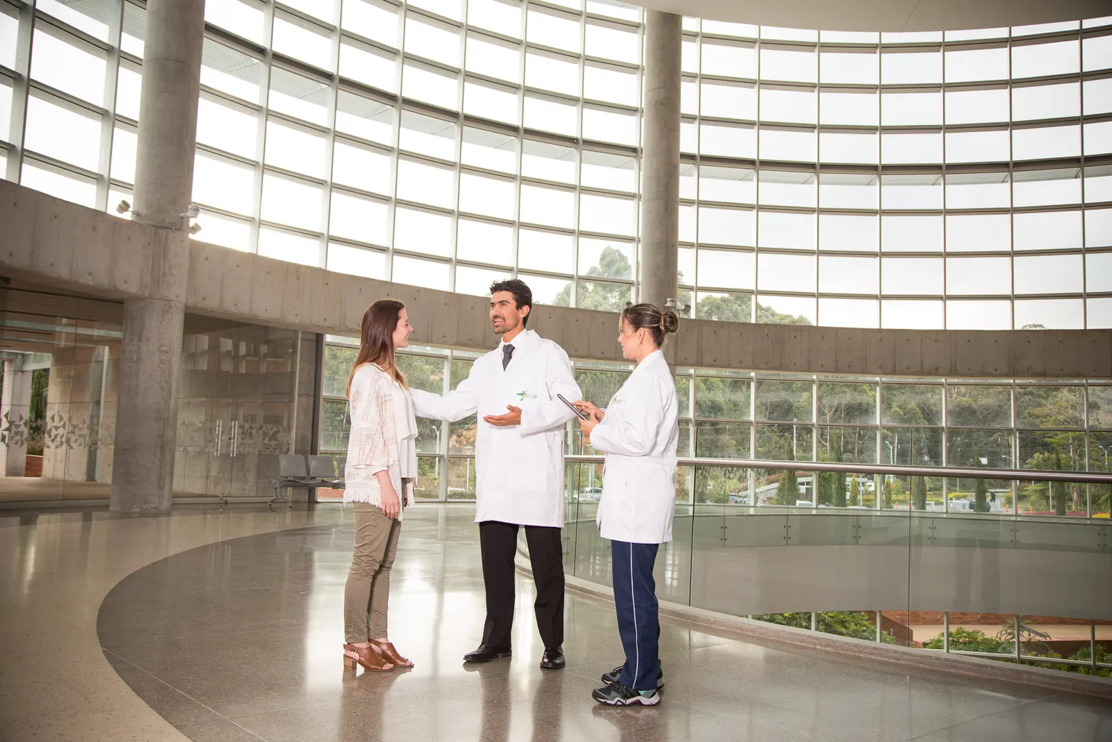 Physicians and a coordinator meeting with a patient in a modern clinic